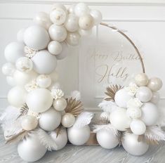 a balloon arch with white and gold decorations