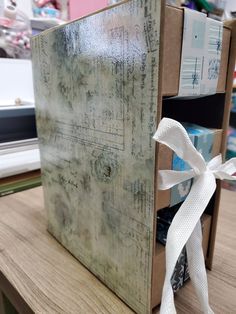 a wooden box with white ribbon tied around it