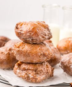 a stack of doughnuts sitting on top of a plate next to a glass of milk