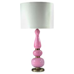 a pink lamp sitting on top of a table next to a white lampshade