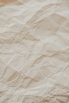 an orange cat laying on top of a bed next to a white sheet of paper