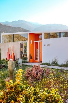 an orange and white house with mountains in the background