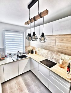 a kitchen with some lights hanging over the sink