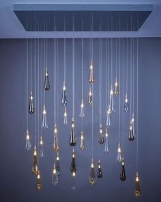 a bunch of lights hanging from the ceiling in a room with blue walls and flooring