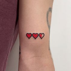 a woman's arm with three red hearts on the left side of her arm