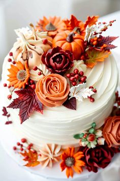 a white cake decorated with flowers and leaves