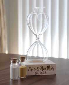 an hourglass and salt shaker sitting on top of a wooden table