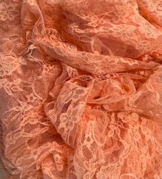 an orange lace fabric is laying on the ground