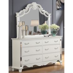 a white dresser and mirror in a room