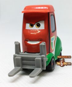 the toy truck is red and green with yellow eyes