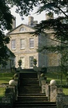 an old mansion with stone steps leading up to it