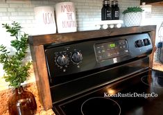 a black stove top oven sitting inside of a kitchen next to a potted plant