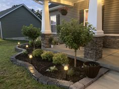 the front porch is lit up with candles and landscaping supplies for an inviting evening scene