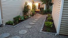 a house with a walkway leading to the front door and side yard area that has stepping stones on it