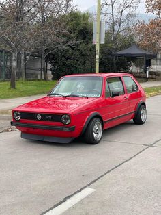 a red car is parked on the street