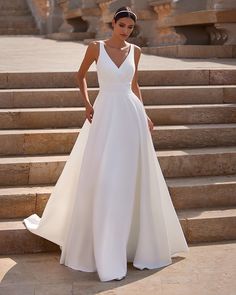 a woman in a white dress standing on some steps