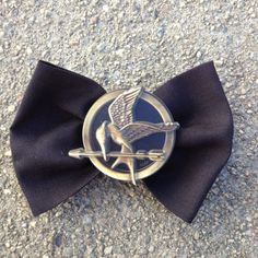 a black bow tie with a silver bird on the front and an arrow in the middle