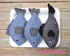 three felt fish sitting on top of a white tray