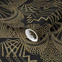 a black and gold wallpaper with an intricate design on it's surface,