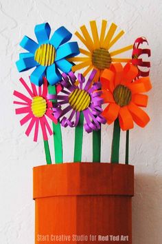 colorful paper flowers in an orange flower pot