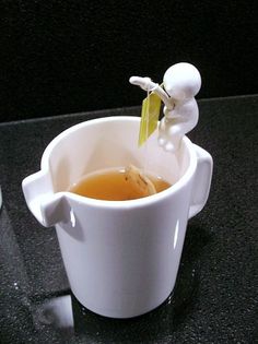 a white cup filled with liquid sitting on top of a table