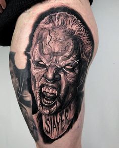 a man's leg with a tattoo on it that says slayer and an evil face