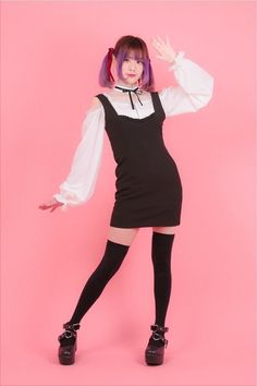 a woman in black and white dress posing with her hands behind her head while wearing thigh high socks