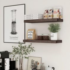 two wooden shelves with coffee cups and other items on them in a white living room