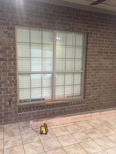 an empty room with a window and tile floor