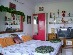 a bed room with a neatly made bed and a tv