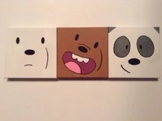 three pieces of paper with faces painted on them, one is brown and the other is white