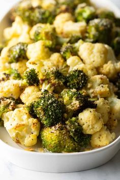 a white bowl filled with broccoli and cauliflower