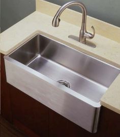 a stainless steel kitchen sink under a faucet in a countertop space with marble counters