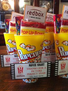 popcorn buckets sitting on top of a wooden table