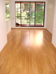 an empty room with wood floors and sliding glass doors