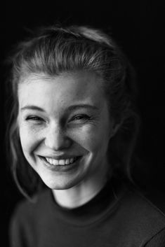 a black and white photo of a woman smiling