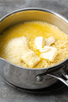 a pot filled with food and butter on top of a counter next to a spoon