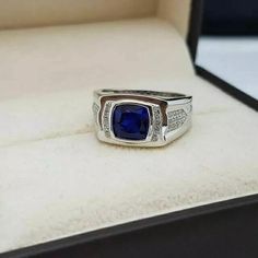 a men's ring with a blue stone in it