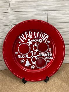 a red plate sitting on top of a wooden table next to a white board with words that read nap santa goes