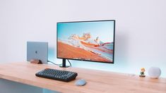 a computer monitor sitting on top of a wooden desk next to a keyboard and mouse