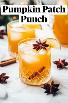 two glasses filled with pumpkin patch punch on top of a white marble table next to an orange slice and star anise