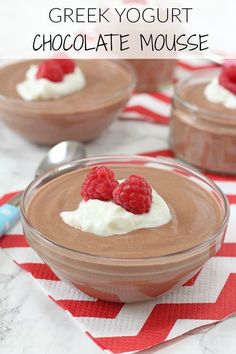 three desserts with raspberries and whipped cream in small bowls on a red and white tablecloth