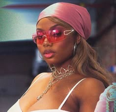 a woman wearing sunglasses and a pink head scarf