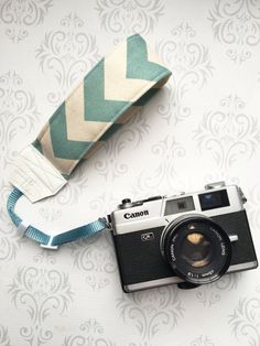 an old camera is sitting next to a roll of fabric