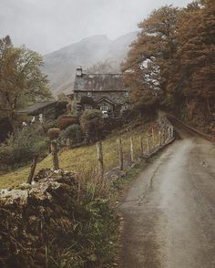 an old country road with a house on the side