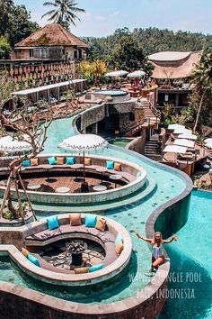 an outdoor swimming pool surrounded by lounge chairs and umbrellas