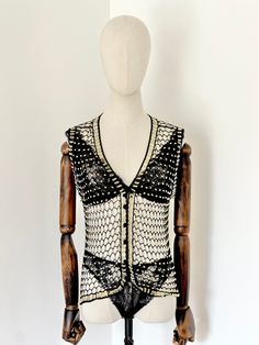 "Glitz" is such an amazing  1970's waistcoat  She has the most amazing hand beaded design Carefully sewn with black and gold beads She is absolutely amazing She has quite a loose fit depending on size Best Fit: S/M Measurements Lying Flat: SHOULDER 37CM 14.5" BUST 51CM 20" LENGTH 57CM 22" Model: UK10 5'7ft All Strobe Vintage pieces have been hand picked and freshly laundered. Due to the age of the garments please except some slight wear and tear as with any vintage it has had a life before hand. Bohemian Fitted Vest For Party, Fitted Bohemian Vest For Party, Vintage Party Vest For Spring, Vintage Spring Party Vest, Spring Party Vintage Vest, Vintage Party Vest For Summer, Vintage Summer Party Vest, Beaded Vest, Crochet Black