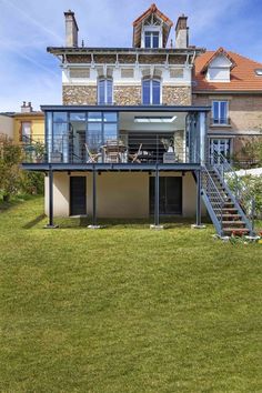 a large house that is in the middle of a grassy area with stairs leading up to it