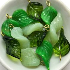 green and yellow glass leaves in a white bowl