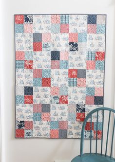 a blue chair sitting in front of a quilt